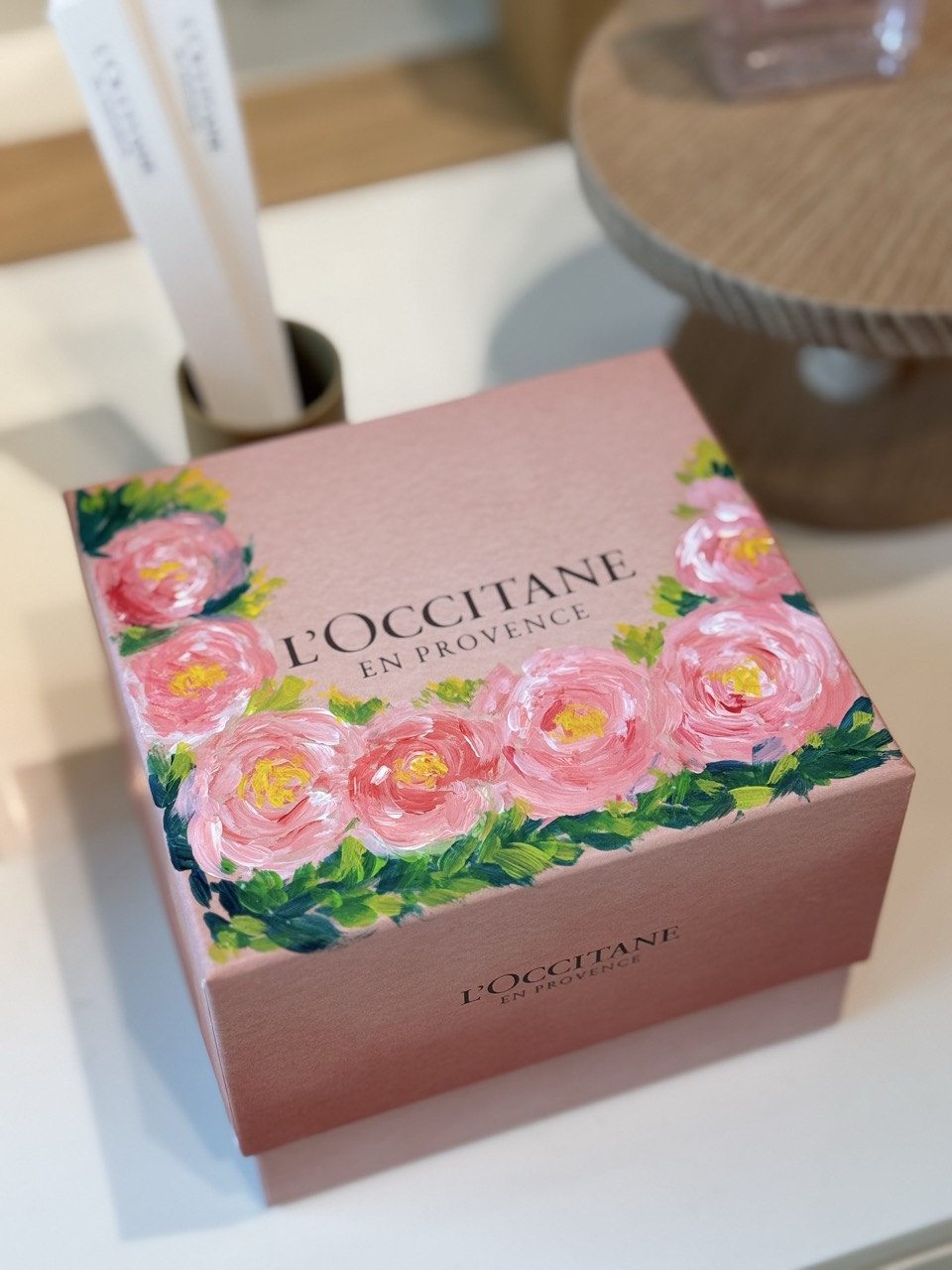 Picture of a beautiful L'Occitane gift box which has a range of pink roses painted over it by hand