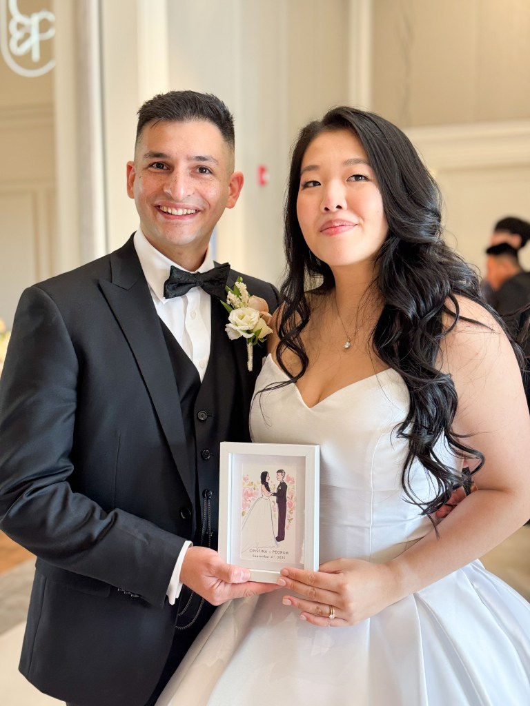 Photo of bride and groom holding custom tehremy live fashion illustration at wedding